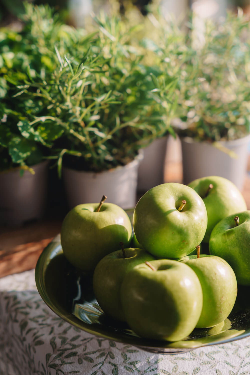 Bowl of green apples with herbs